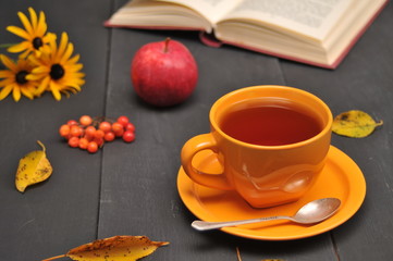 Autumn still life cup of tea, flowers and book on the table