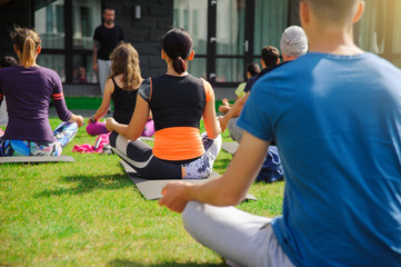 Group of adults attending a yoga class outside in yard