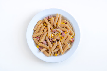 top view of wholemeal pasta, the sauce is made up of kernels of corn and pieces of meat.