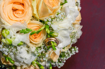 Bouquet of flowers of the bride. Wedding bouquet of flowers with wedding rings. Bouquet of flowers of peach-colored roses, eustomises.