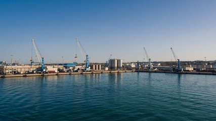 Obraz premium Shipping industrial trade port. Crane bridge and import export container at shipping port harbor.