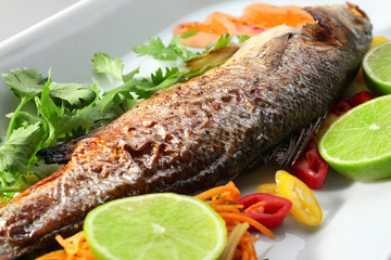 Plate with delicious fish, sauce and garnish, closeup