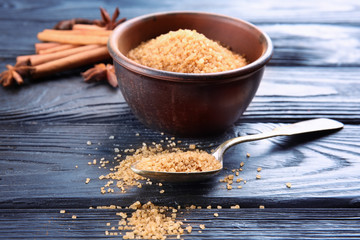 Bowl and spoon with cinnamon sugar on wooden table