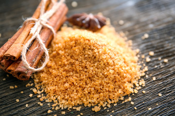 Sweet cinnamon sugar and sticks on wooden background