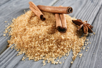 Sweet cinnamon sugar and sticks on wooden background