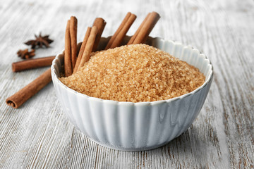 Bowl with cinnamon sugar and sticks on wooden table