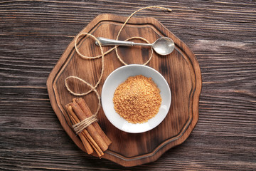 Sweet cinnamon sugar and sticks on wooden background