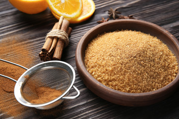 Composition with cinnamon sugar, sticks and powder on wooden background