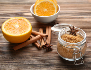 Glass jar with sweet cinnamon sugar and sticks on wooden background