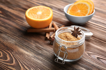 Glass jar with sweet cinnamon sugar and sticks on wooden background