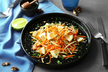 Plate with tasty carrot salad on table
