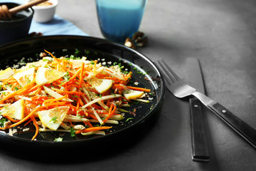 Plate with tasty carrot salad on table