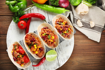Composition with chili con carne, tortillas and products on kitchen table