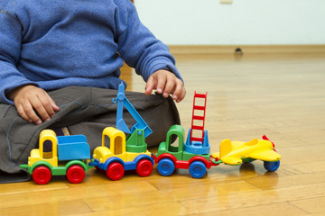 Obraz premium Babe playing cars on the floor