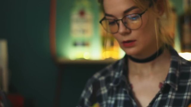 Young beautiful stylish girl bartender barmaid preparing alcohol beverage cocktail nightclub bar portrait closeup glasses ice orange lime straw barman barkeeper professional service traveling party