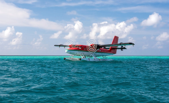 Red seaplane is taking off at the airport in Maldives