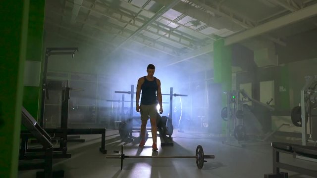 The man lifting a burbell in the fitness center. slow motion