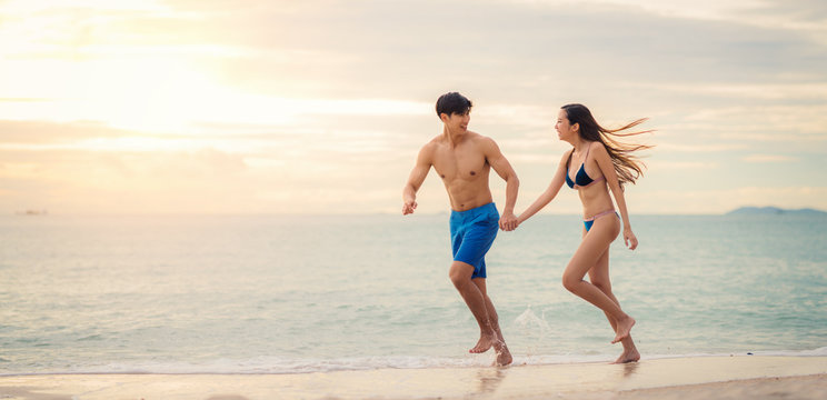 Asian couple run togather on the beach