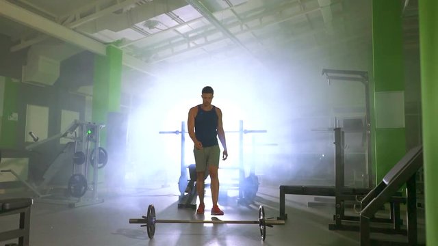 The sportsman lifting a burbell in the fitness center. slow motion
