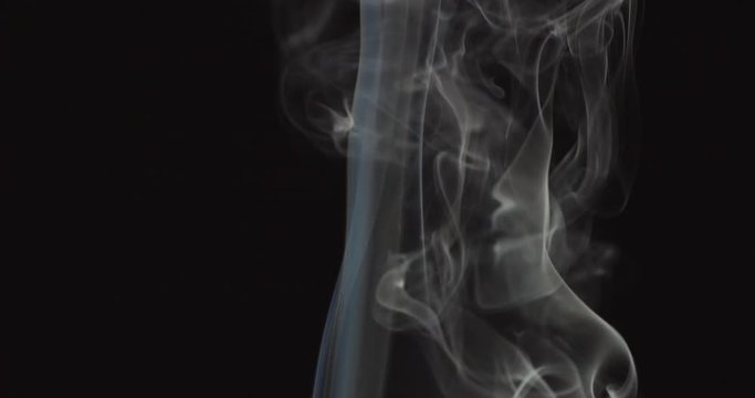 Candle blown out and white smoke rising up on black background
