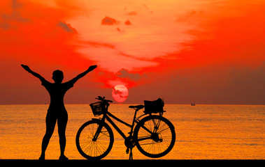 silhouette girl with a bicycle at sunset.