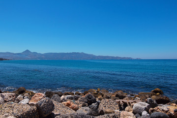 Greek coast, mountains, sea, sky, sun.