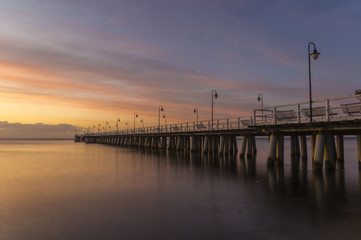 Fototapeta na wymiar Beautiful sunrise over a wooden pier in Gdynia, Poland