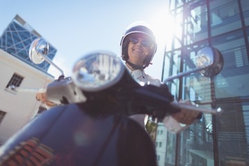 Low angle view of woman riding motor scooter