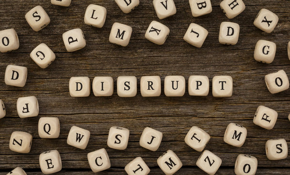 Word DISRUPT made with wood building blocks