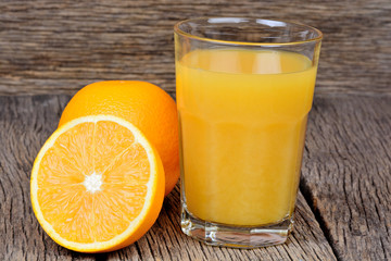 Glass with orange juice on table