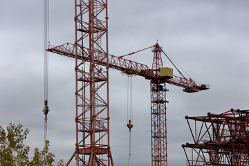 Red construction crane on a gray sky background