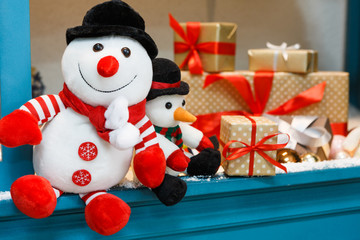 Cozy christmas background. Toy snowmen and presents under new year tree