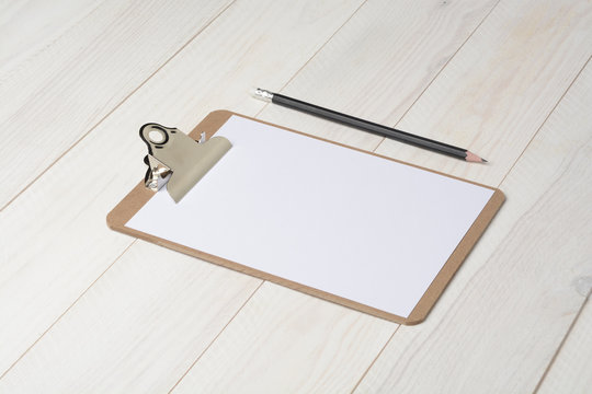 Carpeta portadocumentos y l&aacute;piz sobre fondo de madera blanca