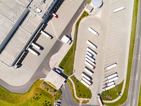 Aerial view of warehouse with trucks. Industrial background. Logistics from above. 