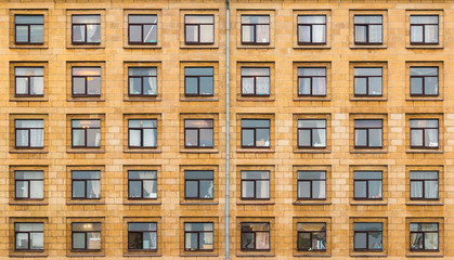 Many windows in a row on facade of urban apartment building front view, St. Petersburg, Russia