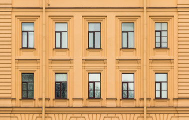 Fototapeta premium Many windows in a row on facade of urban office building front view, St. Petersburg, Russia