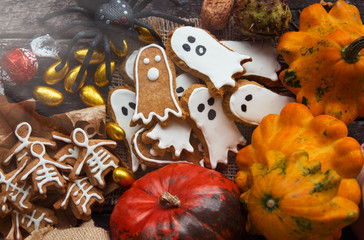 Funny delicious ginger biscuits for Halloween shape ghost and skeleton  with pumpkins and sweets. holiday text 