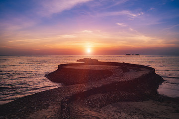 The rock looks like a python in a beautiful sea at sunset in koh chang of thailand.