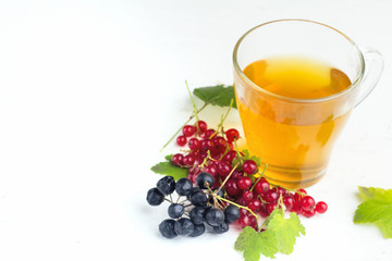 herbal tea in a cup, red currant, chokeberry, on white background.