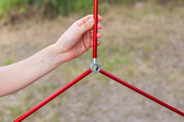 Close up detail of camping tent. Aluminum tent poles. Process of installing tent, setting up tent outdoors.