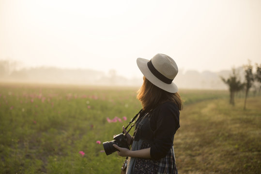 Woman tourist photographer is travel at flower field while sunset.