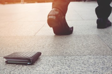 businessman had lost leather wallet with money on the street. Close-up of wallet lying on the sidewalk in during the trip to work.