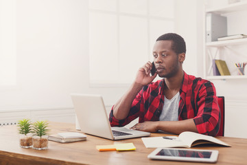 Fototapeta premium Young black businessman call mobile phone in modern white office