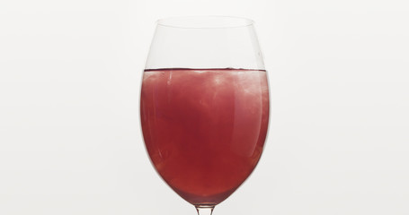 pour blueberry juice into water in wine glass