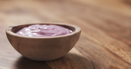 blueberry yogurt in wood bowl on table