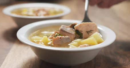 closeup eating fish soup with salmon