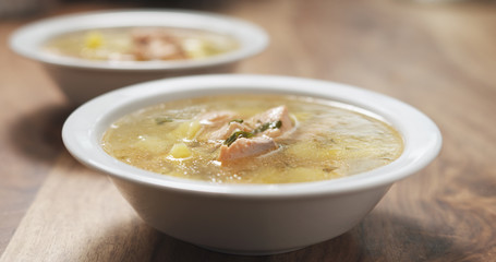 closeup fish soup with salmon on wood table
