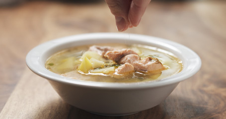 closeup salting fish soup with salmon on wood table