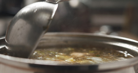 closeup scooping fish soup with salmon