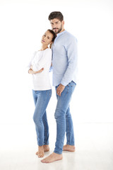 Happy young couple standing at white background 